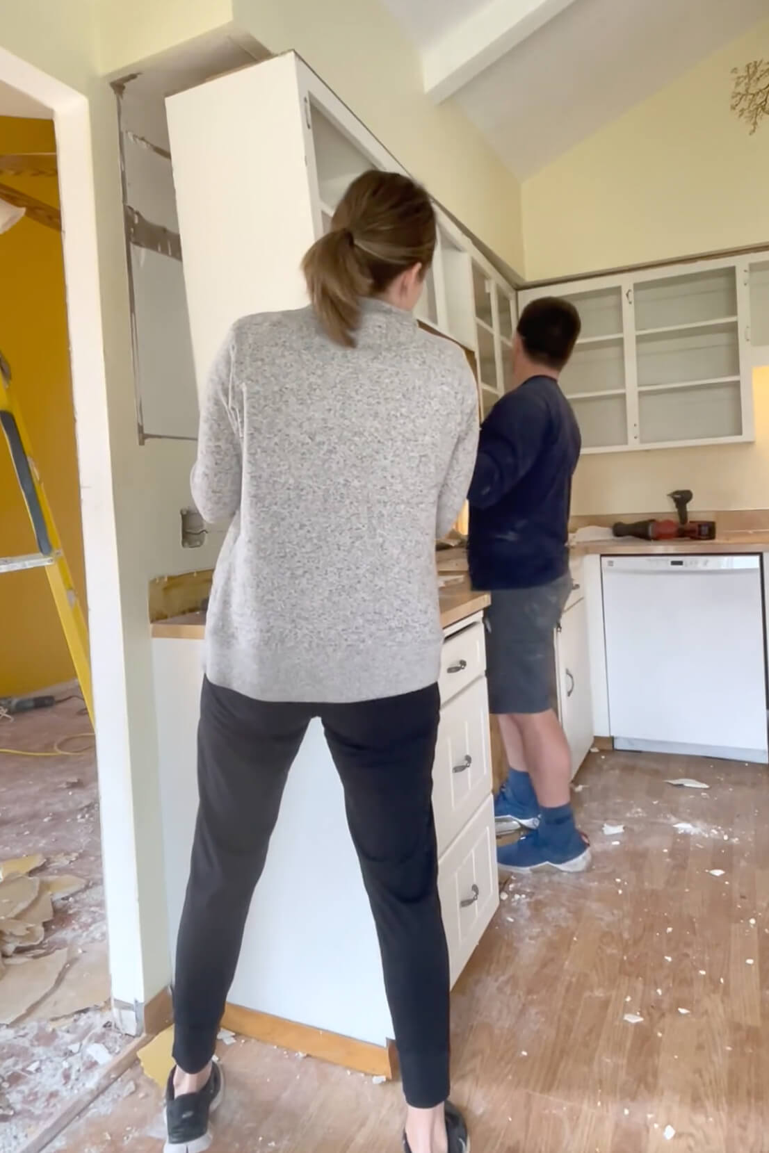 Removing old cabinets during DIY kitchen remodel.